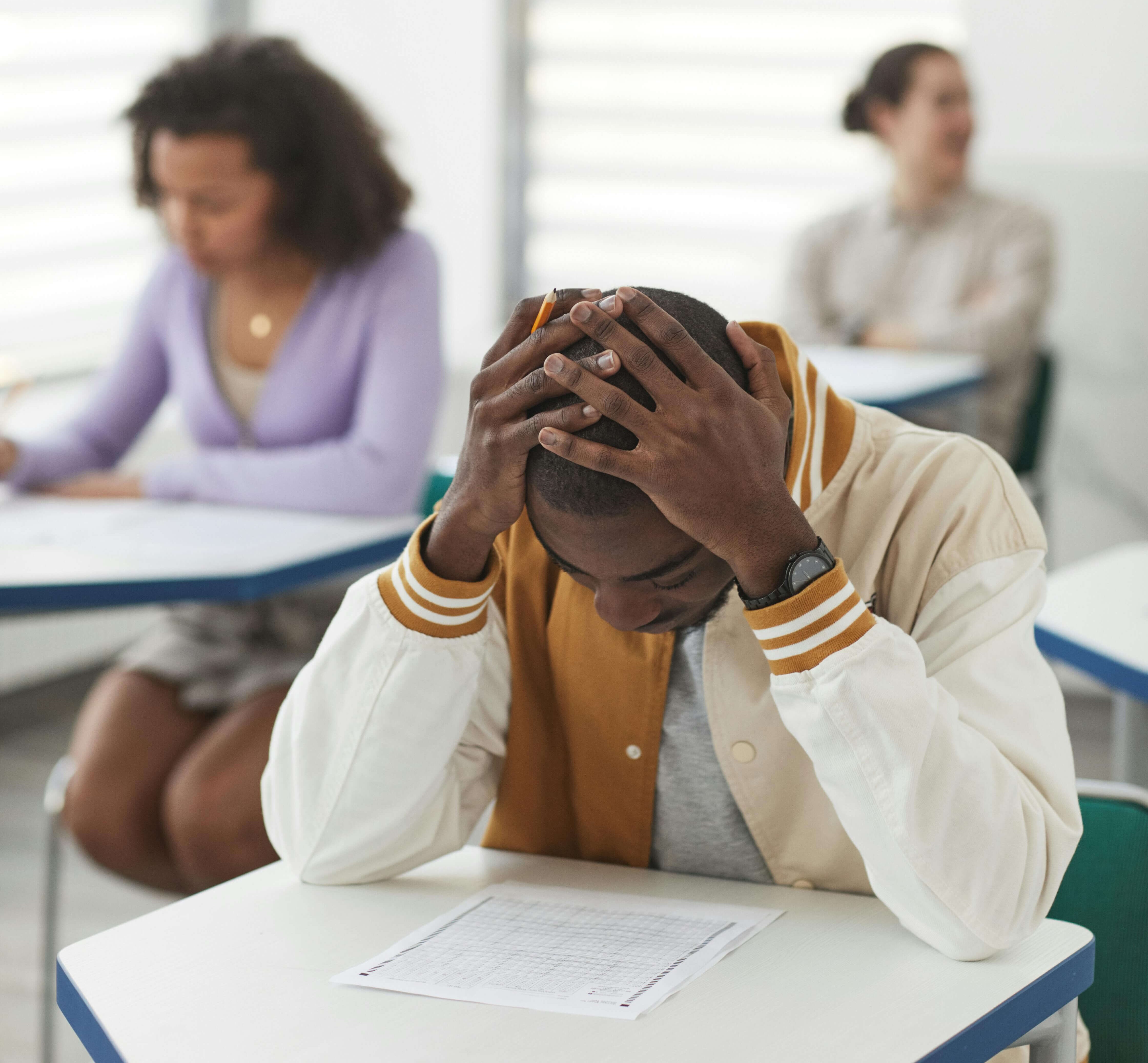 Struggling male student stressing over taking a test